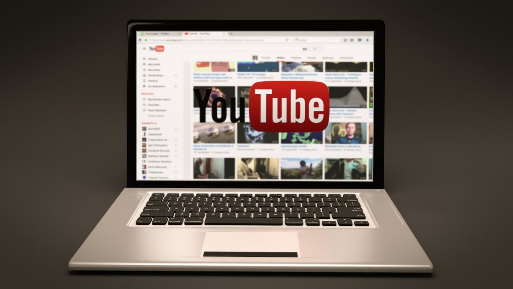 Image of laptop with YouTube logo superimposed over the screen